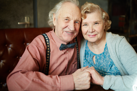 A happy elderly couple holding hands